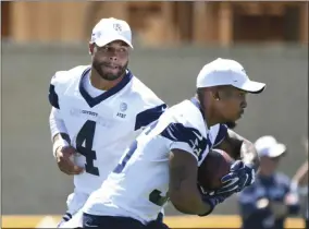  ?? MICHAEL OWEN BAKER - THE ASSOCIATED PRESS ?? Dallas Cowboys quarterbac­k Dak Prescott (4) hands the football to running back Tony Pollard during practice at the NFL football team’s training camp in Oxnard, Calif., Saturday, July 27, 2019.