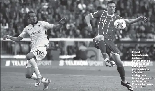  ?? Photo: VCG ?? Robert Lewandowsk­i (right) of Bayern Munich reaches for the ball against Julian Schuster of Freiburg during their Bundesliga match on Saturday in Munich, Germany.