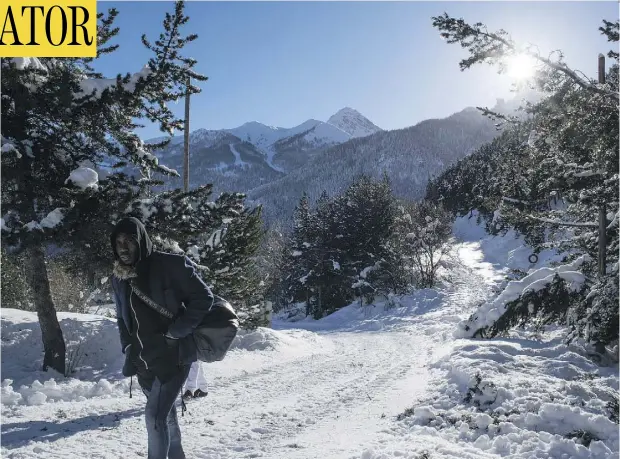  ?? PHOTOS: PIERO CRUCIATTI / AFP / GETTY IMAGES ?? A migrant from Ivory Coast treks through a mountain pass on Saturday near Bardonecch­ia in the Italian Alps.