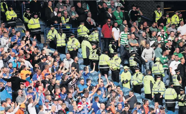  ??  ?? GREAT DIVIDE
Police officers line up between Rangers and Celtic fans at the Ibrox Stadium just before the Old Firm game last September
Pic
Reuters