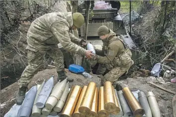  ?? Iryna Rybakova Associated Press ?? UKRAINIAN SOLDIERS prepare howitzer shells on Thursday in Chasiv Yar, the site of heavy battles with Russian forces in the Donetsk region. Officials have talked for months of a coming Ukrainian counterpun­ch.