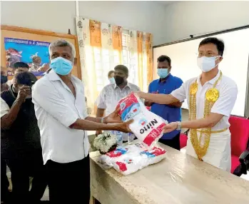  ?? ?? Ambassador Qi Zhenhong distributi­ng food packs to northern fishermen during the visit