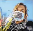  ??  ?? A woman wears a face mask with the words ‘I’m a teacher’ on it in tribute to Samuel Paty