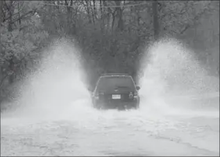  ?? GARY YOKOYAMA, THE HAMILTON SPECTATOR ?? Passenger vehicle heading east on a partially flooded King Street East, toward Olympic Drive, in Dundas.