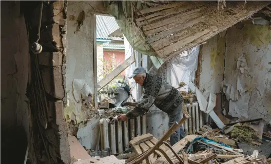  ?? ALEXEY FURMAN/GETTY IMAGES ?? Yurii, 53, shows the holes in his heavily damaged house, on Monday in Fenevychi, Ukraine.