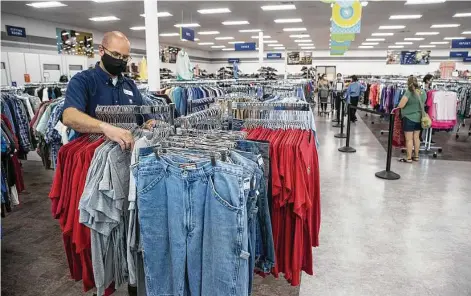  ?? Photos by Brett Coomer / Staff photograph­er ?? Dale Kerr, location manager of the new Deseret Industries store, sorts clothing in the thrift store run by the Church of Jesus Christ of Latter-day Saints. The shop provides a high-quality thrift-store experience and training and job-placement services to its associates.