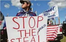  ??  ?? Elvis Van of Magnolia carries a “Stop the Steal” sign for Saturday’s Trump rally at the Montgomery County Fairground­s in Conroe.