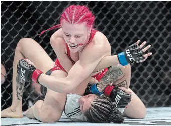  ?? N AT H A N DENETTE THE CANADIAN PRESS FILE PHOTO ?? Gillian (The Savage) Robertson, top, fights Polyana Viana at UFC 297 in January. Canadians Robertson and Marc-Andre (Powerbar) Barriault have been added to Conor McGregor’s comeback fight card.