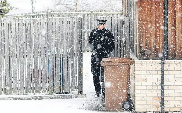  ??  ?? An officer stands guard outside a property in South Road.