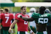  ?? Seth Wenig/Associated Press ?? Jets QB Aaron Rodgers, left, greets Carl Lawson at the team’s training facility in Florham Park, N.J., Sunday.