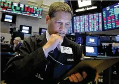  ?? RICHARD DREW / ASSOCIATED PRESS ?? Trader Craig Esposito works on the floor of the New York Stock Exchange on Monday. The S&P 500 rose 16 points, or 0.6 %, to a record 3,039, while the Dow Jones Industrial Average added 132 points, or 0.5%, to 27,090 in a strong start to the week on Wall Street.