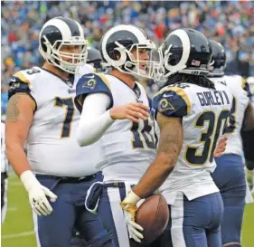  ?? THE ASSOCIATED PRESS ?? Los Angeles Rams running back Todd Gurley celebrates with quarterbac­k Jared Goff, center, after Gurley scored on an 11-yard touchdown pass from Goff during Sunday’s game against the Tennessee Titans in Nashville. The Rams won 27-23 and clinched the NFC...