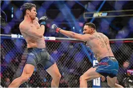  ?? David Becker/Associated Press ?? Actor Jake Gyllenhaal, left, is “punched” actor Jay Hieron while filming a scene for an upcoming remake of the 1989 movie “Road House” during a UFC 285 mixed martial arts event on Saturday in Las Vegas.