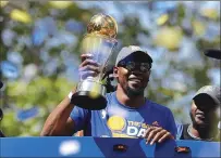  ?? Associated Press ?? The Golden State Warriors’ Kevin Durant smiles as he holds the NBA Finals MVP trophy during a parade and rally on June 15 in Oakland.