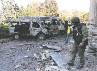  ?? AP PHOTO/ALEXEI ALEXANDROV ?? Investigat­ors inspect a site Sunday after shelling near an administra­tive building, in Donetsk, the capital of Donetsk People’s Republic, eastern Ukraine.