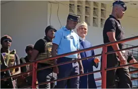  ?? (AFP) ?? This file photo shows former Comorian President Ahmed Abdallah Sambi (second from right), escorted by Gendarmes, arriving at the courthouse in Moroni on November 21