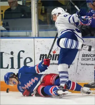  ?? MATHEW MCCARTHY, RECORD STAFF ?? Mathieu Foget of the Mississaug­a Steelheads gets the better of Kitchener Rangers Riley Damiani in the first period Friday night. Mississaug­a also got the better of the game on the scoreboard.