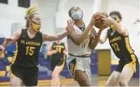  ?? STEVE JOHNSTON/DAILY SOUTHTOWN ?? Chicago Christian’s Charity Love drives to the basket as St. Laurence’s Ryann Houbolt, left, and Kathleen Martin defend during a 2021 game.