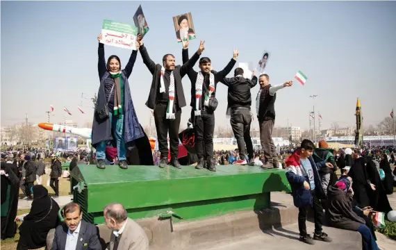  ?? Reuters ?? Crowds in Tehran’s Azadi Square hold up portraits of the supreme leader, Ayatollah Ali Khamenei, as well as of the founder of the Islamic republic, Ayatollah Ruhollah Khomeini, at Sunday’s rally.