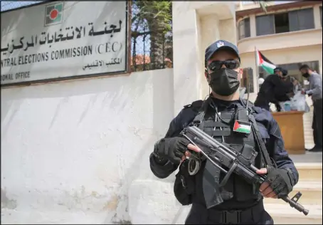  ??  ?? شرطي فلسطيني في حراسة لجنة الانتخابات المركزية