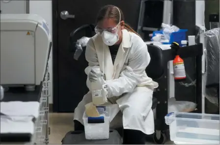  ?? THE ASSOCIATED PRESS ?? A laboratory assistant holds sewage samples collected from a Utah State University dormitory Sept. 2, in Logan, Utah. About 300 students are quarantine­d to their rooms this week, but not because anyone got sick or tested positive. Instead, the warning bells came from the sewage. Colleges around the country are monitoring wastewater in hopes of stopping coronaviru­s outbreaks before they get out of hand. Utah State became at least the second school to quarantine hundreds of students after sewage tests detected the virus.