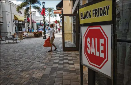  ?? CALLA KESSLER / THE PALM BEACH POST ?? Crowds at Palm Beach Outlets were thin early Friday morning, but by mid-morning, shoppers were streaming in, a spokeswoma­n for the outlets said. A growing number of stores began offering Black Friday-like promotions on Monday.