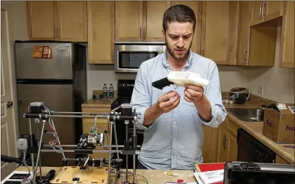  ?? AUSTIN AMERICAN-STATESMAN 2013 ?? Cody Wilson works on the first completely 3-D-printed handgun, The Liberator, at his home in Austin, Texas ,in May 2013. He soon dropped out of college and uploaded his design files for ghost guns, firearms without serial numbers.