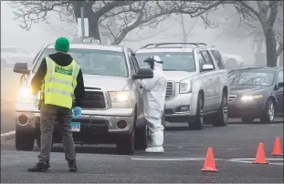  ?? Matthew Brown / Hearst Connecticu­t Media ?? Motorists wait in their cars during a drive-thru coronaviru­s testing program run by staff from Murphy Medical Associates at Cummings Beach in Stamford on March 20.