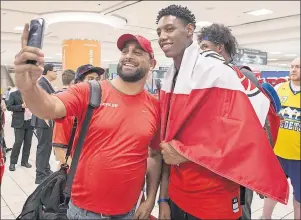  ?? CP PHOTO ?? R.J Barrett, right, has his photo taken with a well-wisher after arriving at Toronto’s Pearson Airport with other members of Canada’s under-19 Basketball team after winning gold at the U19 FIBA World Cup, in Toronto on Monday.