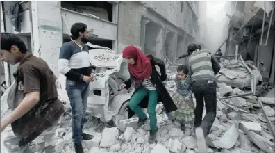  ?? PICTURE: REUTERS ?? A woman holds a girl’s hand as they rush away from a site hit by what activists said was an air strike by forces loyal to Syria’s President Bashar alAssad in Aleppo’s al-Fardous district yesterday.