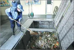  ?? PHOTOS BY ZHANG WEI / CHINA DAILY ?? A worker clears kitchen waste collected from communitie­s near the Xibianmen garbage storage building.