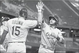  ?? ROSS D. FRANKLIN — THE ASSOCIATED PRESS ?? The A’sJed Lowrie (8) celebrates his three-run home run against the Diamondbac­ks with the A’s Seth Brown (15) during the seventh inning Tuesday in Phoenix.