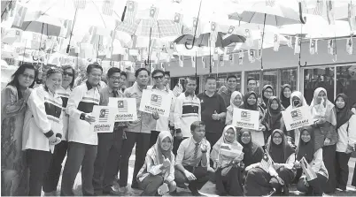  ??  ?? ABAL Mukam (lima kiri) dan Ag Roslan (enam kiri) bersama Pengerusi Permuafaka­tan Komuniti 1Malaysia Negeri Sabah Tahir Mohd Soon (tujuh kiri) semasa Majlis Pelancaran Anjung Payung Merdeka SMK Putatan.
