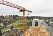  ?? Elaine Thompson / Associated Press ?? An idled constructi­on site in Seattle could soon restart under new rules set by Washington’s governor.
