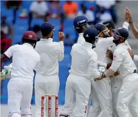  ?? AP ?? Indian players congratula­te captain Virat Kohli after he took a catch off West Indies’ Jermaine Blackwood (left). —