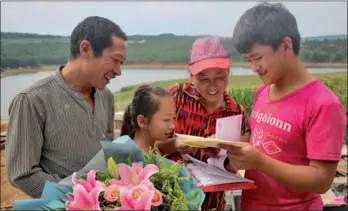  ?? PHOTOS BY CHEN YAOBANG / FOR CHINA DAILY ?? Cui Qingtao (right) and his family share a happy moment upon receiving an admission letter from Peking University. Born in a poor village in Southwest China’s Yunnan province, Cui’s success story has become popular on China’s social media.