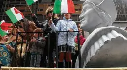  ?? Seth Wenig / Associated Press ?? People in 2012 wave Italian flags while riding a float with a large bust of Christophe­r Columbus during the Columbus Day parade in New York.