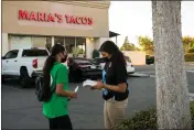  ?? HEIDI DE MARCO — KHN ?? Melissa Lopez (left) and Alma Gallegos get ready to distribute covid tests to a taco shop in Fresno. Both are seniors at Theodore Roosevelt High School participat­ing in the Promotorit­os program, an internship organized by the nonprofit Fresno Building Healthy Communitie­s.