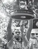  ?? Jamie Squire / Getty Images ?? DeJon Jarreau hoists the Midwest Regional Champion trophy Monday in the NCAA tournament in Indianapol­is.
