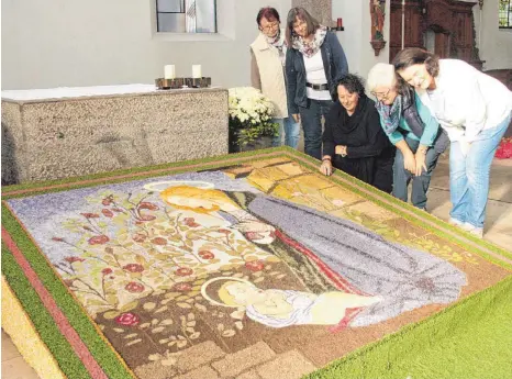  ?? FOTO: WILHELM AMANN ?? Zum des Erntedank liegt ein Früchtetep­pich in der Brochenzel­ler Kirche. Er zeigt die betende Maria mit schlafende­m Jesuskind.