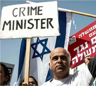  ?? Amir Cohen/Reuters ?? Manifestan­tes protestam pela renúncia do premiê Binyamin Netanyahu, em Tel Aviv
