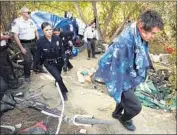  ?? Al Seib Los Angeles Times ?? L.A. POLICE and park rangers clear a homeless encampment at the Sepulveda Basin Wildlife Reserve.