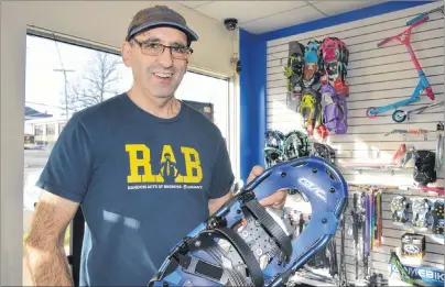  ?? CHRIS SHANNON/CAPE BRETON POST ?? Bill Goldston, owner of FrameWork Cycle & Fitness on George Street in Sydney, holds one of the many lightweigh­t snowshoes he has in stock. He placed snowshoes and bicycles on sale a week in advance of Black Friday but still expects a crowd for the...