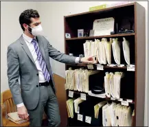  ?? (AP/Gillian Flaccus) ?? Public defender Drew Flood with the nonprofit law firm Metropolit­an Public Defender looks at his current criminal case files on May 5 in Portland, Ore.