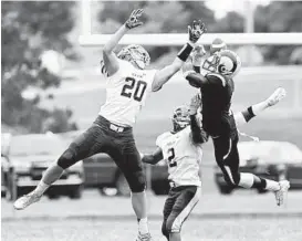  ?? NICOLE MUNCHEL/FOR THE BALTIMORE SUN MEDIA GROUP ?? Hereford’s Zac Johnson (20) and Khalil Rich (2) break up a pass intended for Randallsto­wn’s Michael Akinleye. For video from the game, go to baltimores­un.com/varsity.