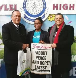  ??  ?? EMPOWERED: Ward 60 councillor Mark RH Kleinschmi­dt presenting Britney Williams with a stationery gift, alongside Professor Brian P Williams, facilitato­r of the peace ambassador­s programme.