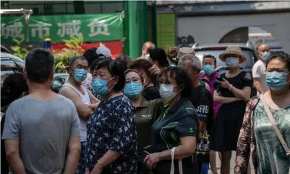  ?? Photograph: Nicolas Asfouri/AFP/Getty Images ?? People under lockdown in a residentia­l compound wait to be transporte­d for Covid-19 testing in Beijing, China, 19 June 2020.