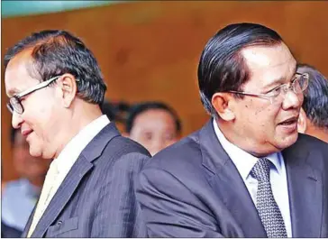  ?? HENG CHIVOAN ?? Sam Rainsy and Hun Sen stand on the steps of the National Assembly in 2014 after a meeting.