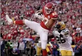  ?? CHARLIE RIEDEL — THE ASSOCIATED PRESS ?? Kansas City Chiefs tight end Travis Kelce (87) catches a touchdown pass as Green Bay Packers safety Darnell Savage (26) defends during the first half of an NFL football game Sunday in Kansas City, Mo.