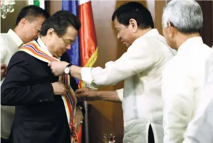  ?? PNA FOTO/ ROBINSON NINAL ?? AWARD. President Rodrigo Roa Duterte confers the Order of Sikatuna Grand Cross Gold Distinctio­n Award to outgoing Vietnam Ambassador Truong Trieu Duong.